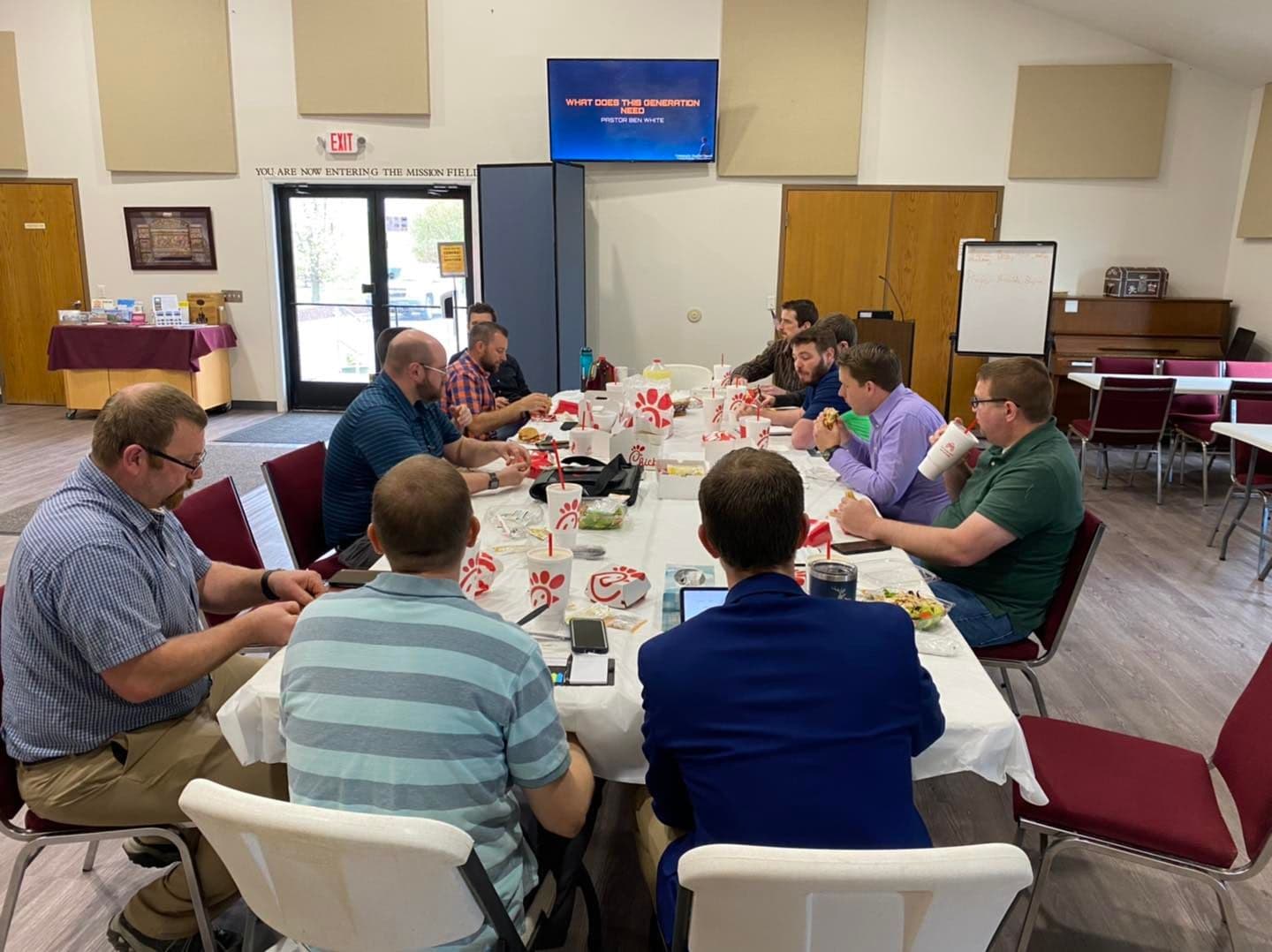 Men of the church eating together at a fellowship meal